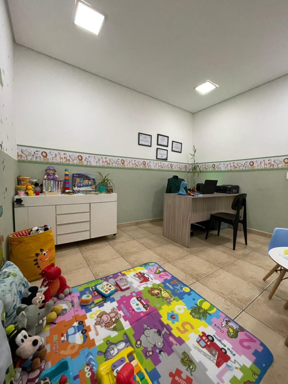Vista ampla do consultório com tapete educativo
