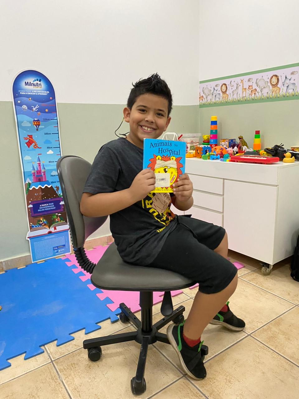 Criança com livro Animais no Hospital